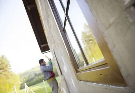 Wooden frame external view of glazier fitting windows to house
